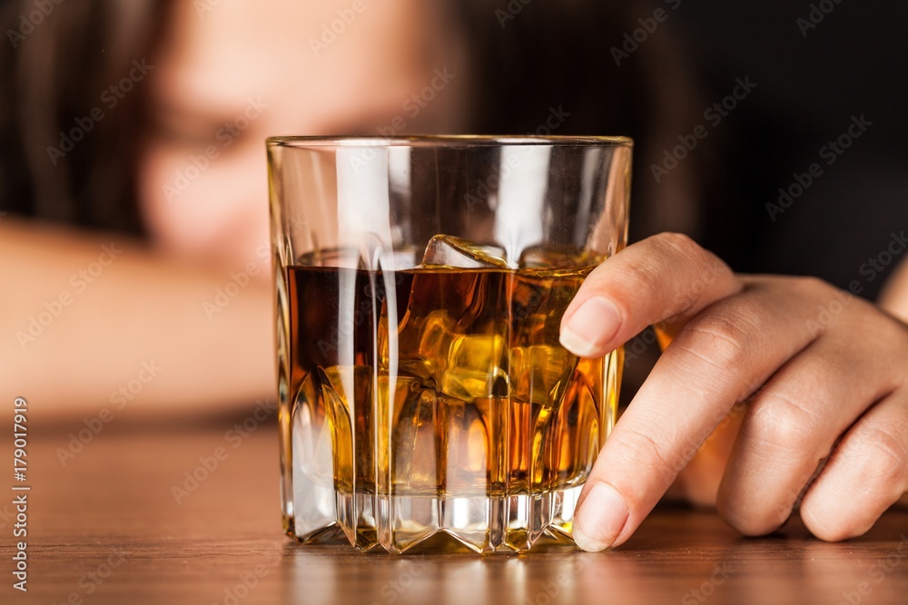 Drunk Woman Sleeping At Bar Counter Holding a Glass of Whisky Drunk Woman Sleeping At Bar Counter Holding a Glass of Whisky