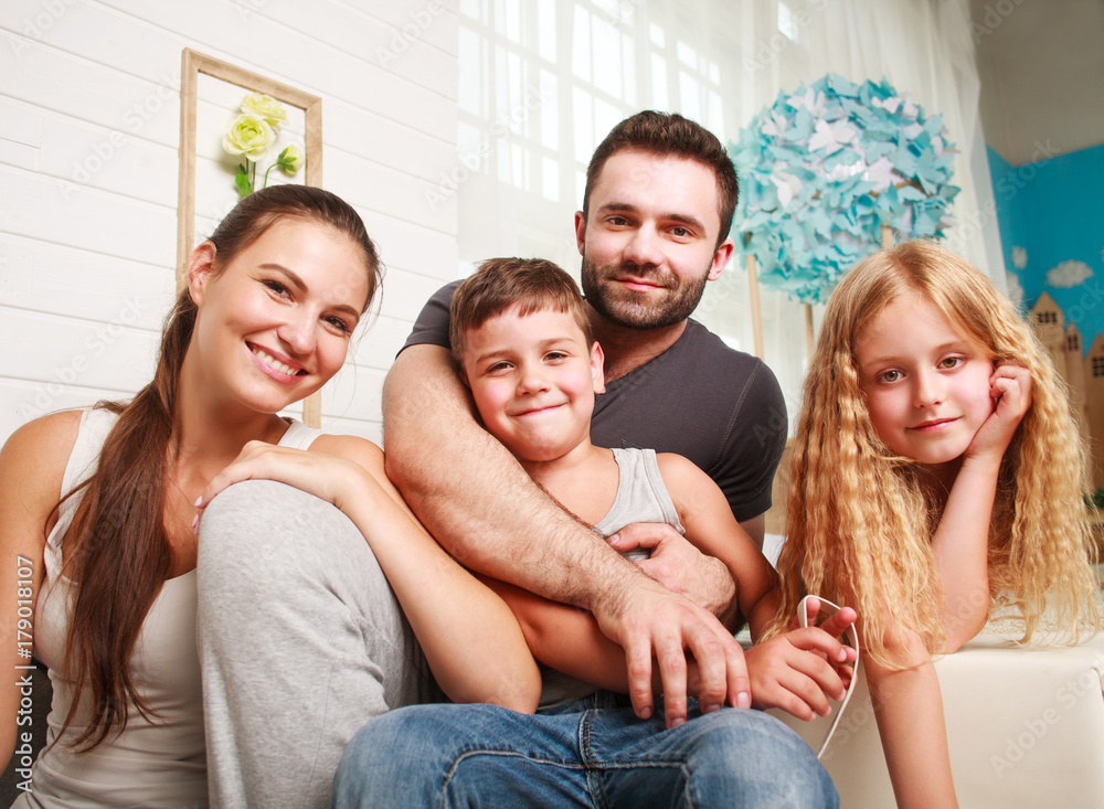 Happy young family of parents with daughter and son at home