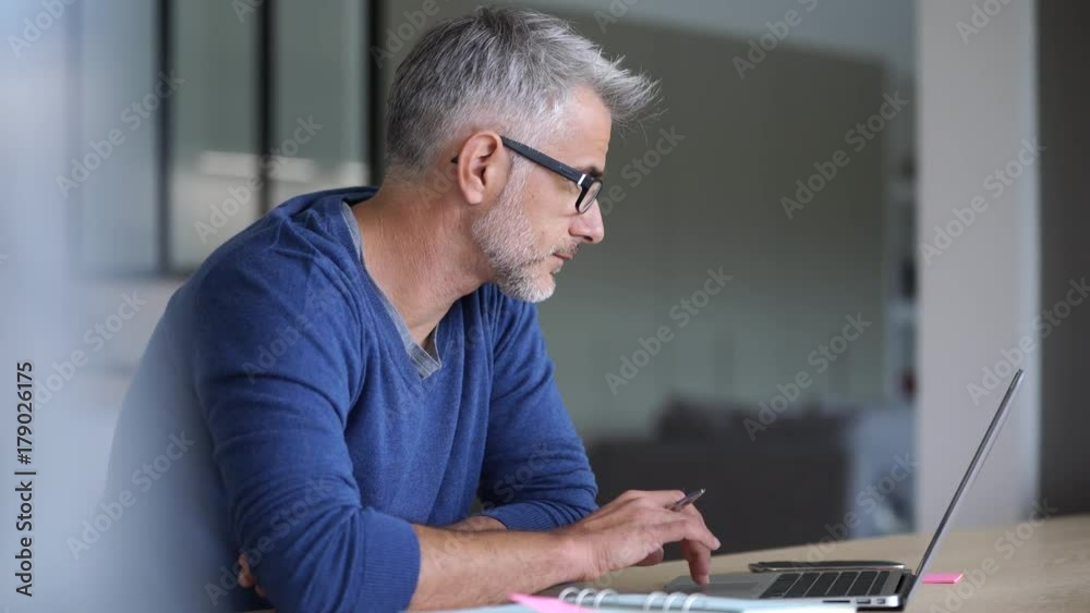 Middle-aged man working from home-office on laptop