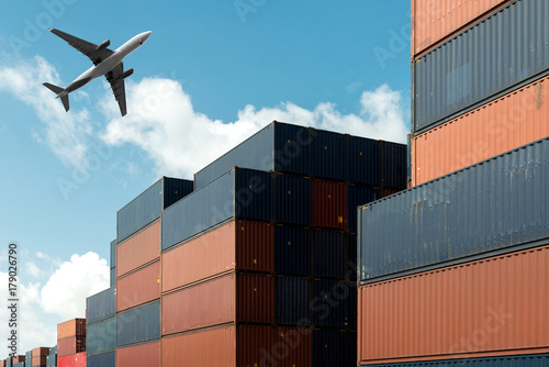 Stack of cargo containers with cargo airplane at import and export area at port.