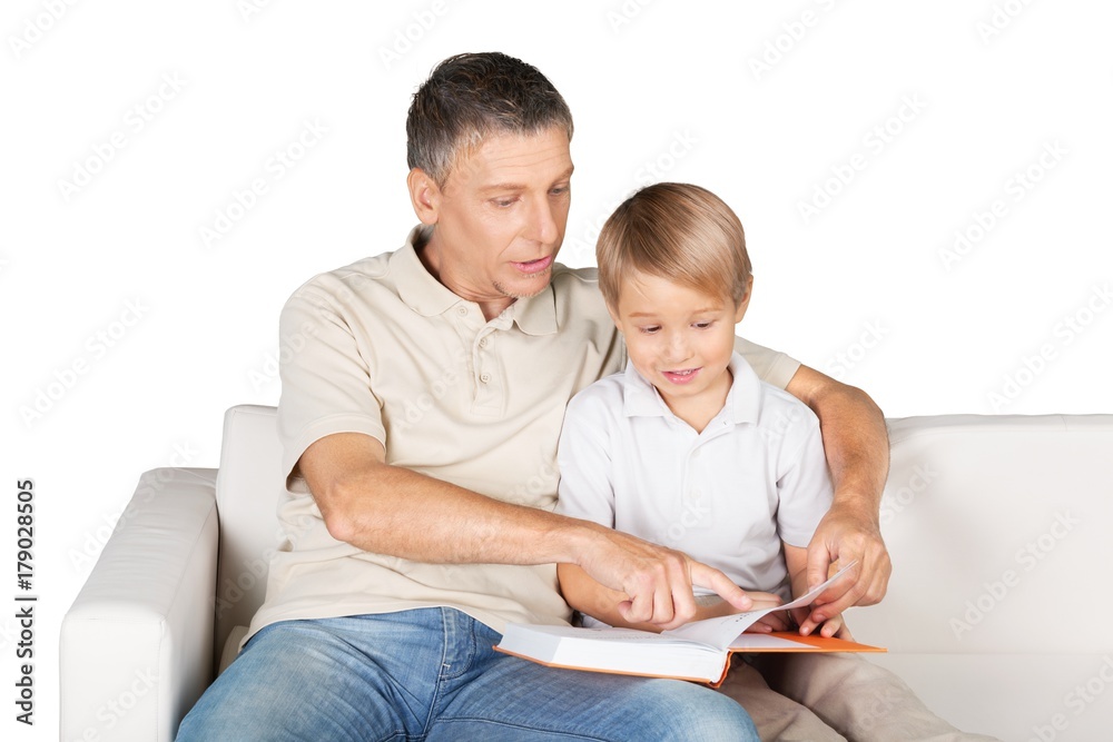 Father and Son Reading a Book on the Couch