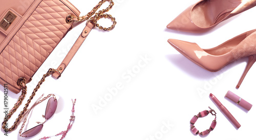 Women's set of fashion accessories in pink color on white background: shoes, handbag, sunglasses, lipsticks and jewelry