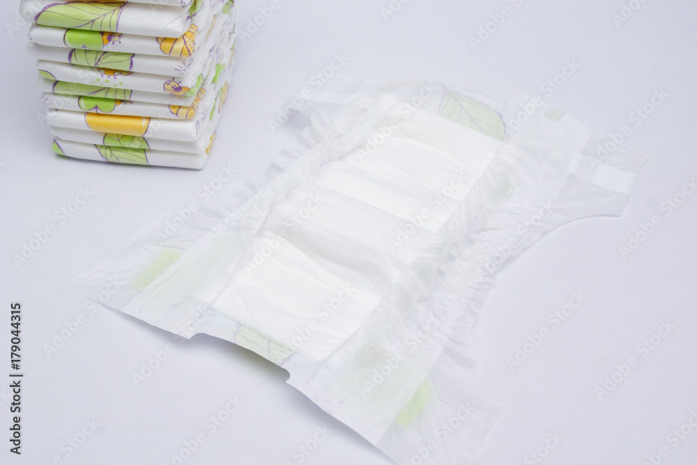 Stack Of Baby Diapers And The Open Diaper In Front