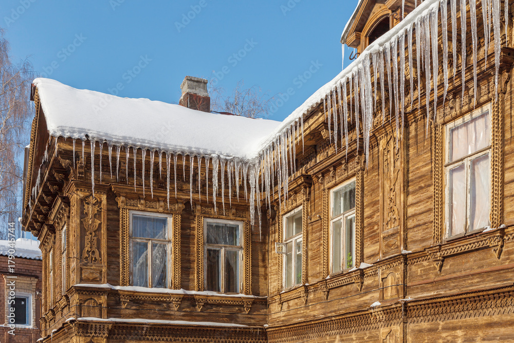 Fragment of a wooden house with icicles