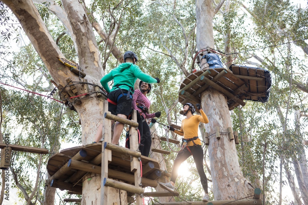 Friends enjoying zip line adventure on vacation
