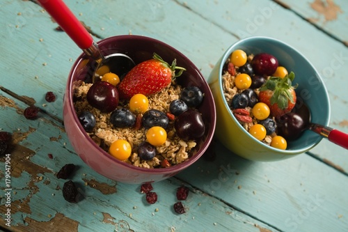 Bowls of breakfast cereals and fruits with spoon photo