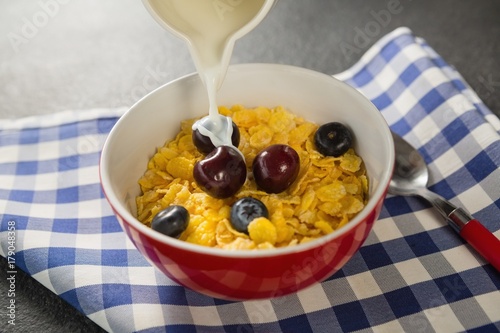 Milk being poured into bowl of wheaties cereal photo