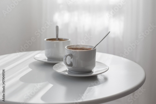 two cups of coffee on white table