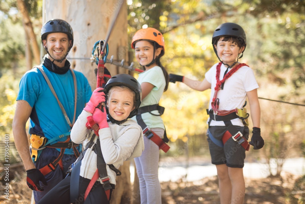 Kids enjoying zip line adventure on sunny day