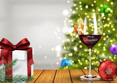 Christmas wine glass with gift boxes and christmas ball on light bokeh background