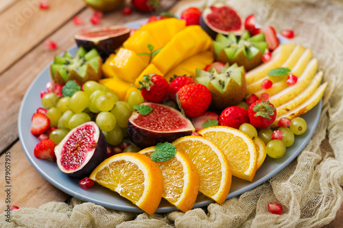 Platter fruits and berries. Mango  kiwi  fig  strawberry  grapes  pear and orange. Vegan cuisine. Dietary menu.