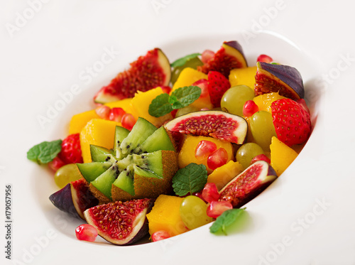 Platter fruits and berries. Mango, kiwi, fig, strawberry, grapes, pear and orange. Vegan cuisine. Dietary menu.