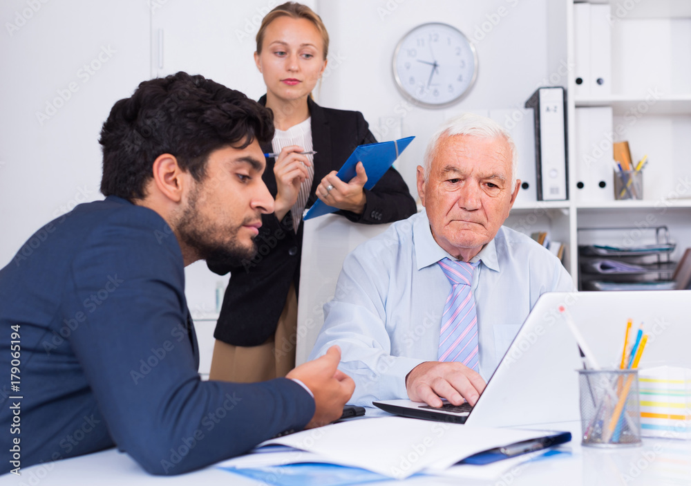 Obraz premium Mature man is talking to colleague