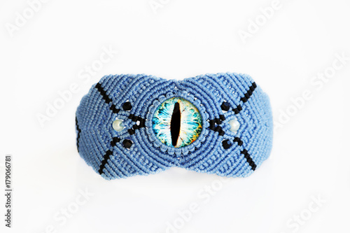 blue bracelet for the hand from waxed thread, and blue dragon eye in the technique of macrame on a white background.