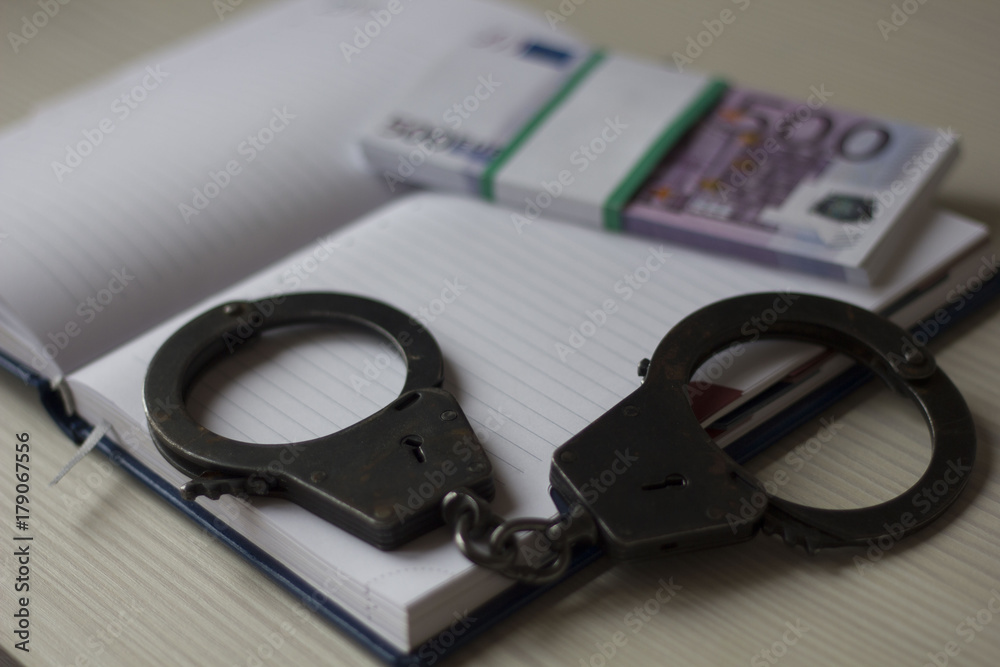 handcuffs and money Notepad on the table handcuffs and money Notepad on the table