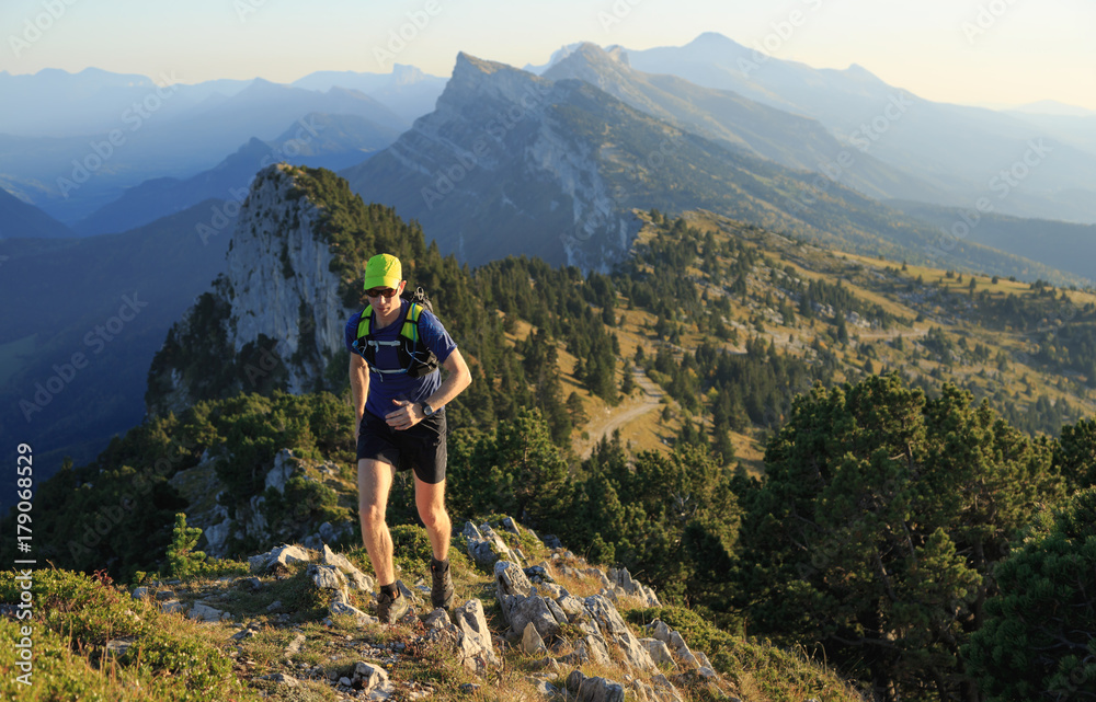 Man trailrunning in the mountains on a beautiful afternoon. Vercors, France.