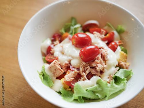 Bowl of Salad Tuna with fresh Leaf vegetable, tomato and cabbage, on wooden table background