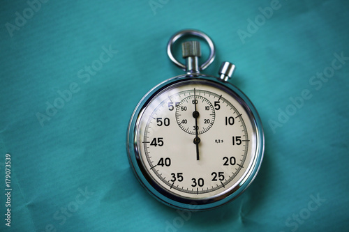 Old stopwatch isolated on paper bright background top view. Concept of business time