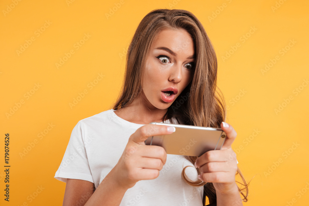 Portrait of an excited cute girl playing games on phone Portrait of an excited cute girl playing games on phone