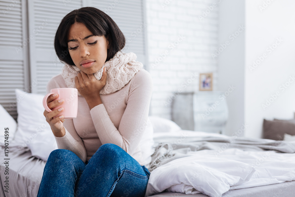 Unhappy young ill woman having a sore throat Unhappy young ill woman having a sore throat
