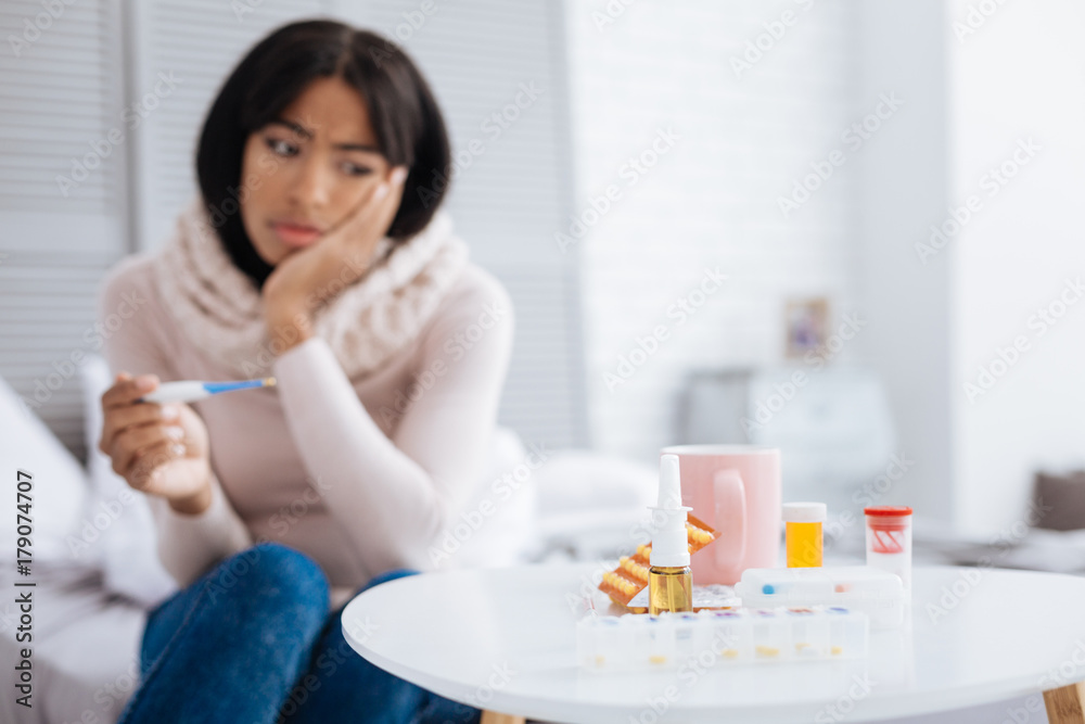 Sad woman looking at all her expensive medicines Sad woman looking at all her expensive medicines