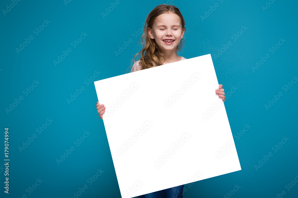 Pretty, little girl in sweater with brunet hair hold clean paper Pretty, little girl in sweater with brunet hair hold clean paper