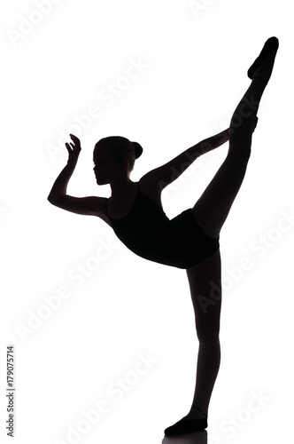 Little cute girl in black leotard making new ballet movement in studio