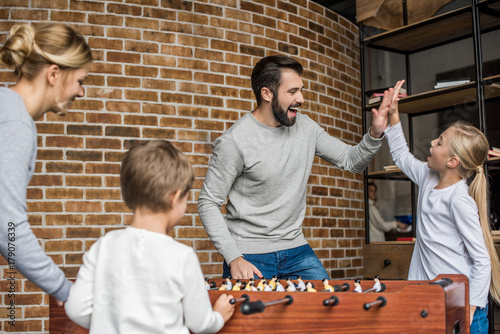 parents and kids playing table football