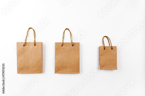 Three paper bags with handles on a white background, top view