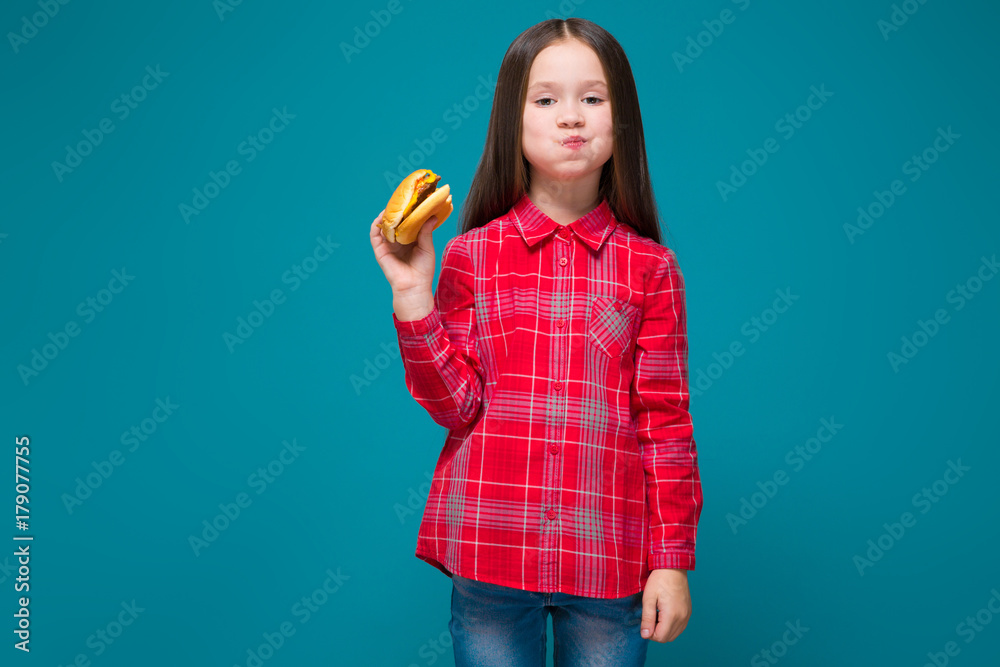 Cute little girl in checkered shirt with brunet hair hold burger Cute little girl in checkered shirt with brunet hair hold burger