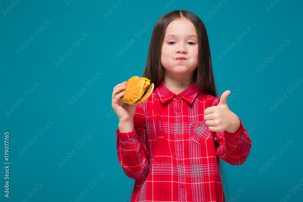 Cute little girl in checkered shirt with brunet hair hold burger Cute little girl in checkered shirt with brunet hair hold burger