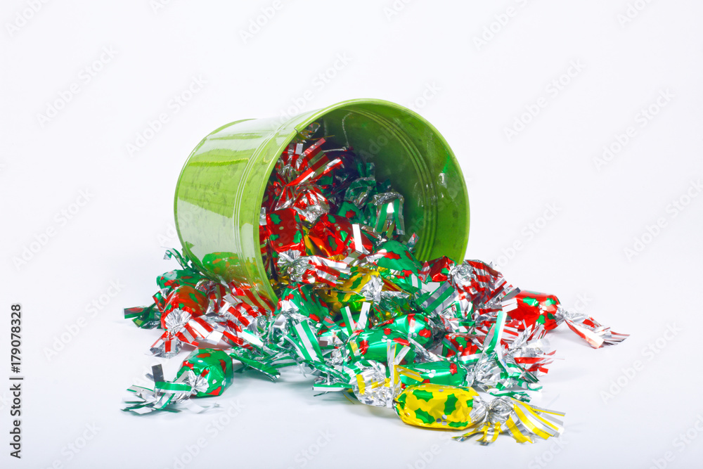 Colorful candy and green bucket on white background