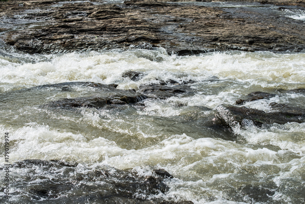 Fast stream of a mountain river runs through the stones. Fast stream of a mountain river runs through the stones.