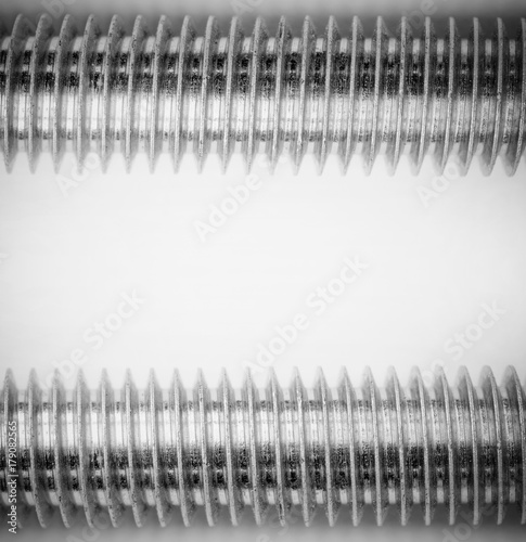 Photography industrial background with a steel thread on the stud on grey background monochrome photo