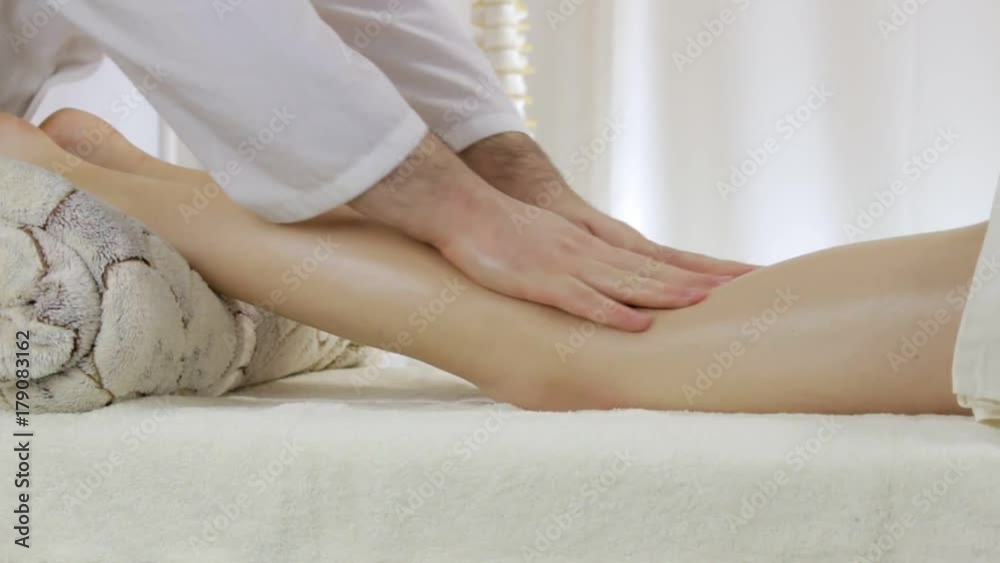 Doctor masseur doing massage of beautiful young girl legs Doctor masseur doing massage of beautiful young girl legs