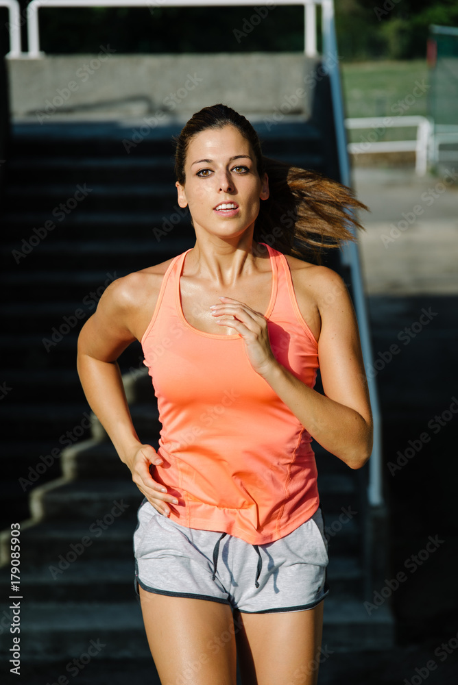 Sporty young woman running and exercising.