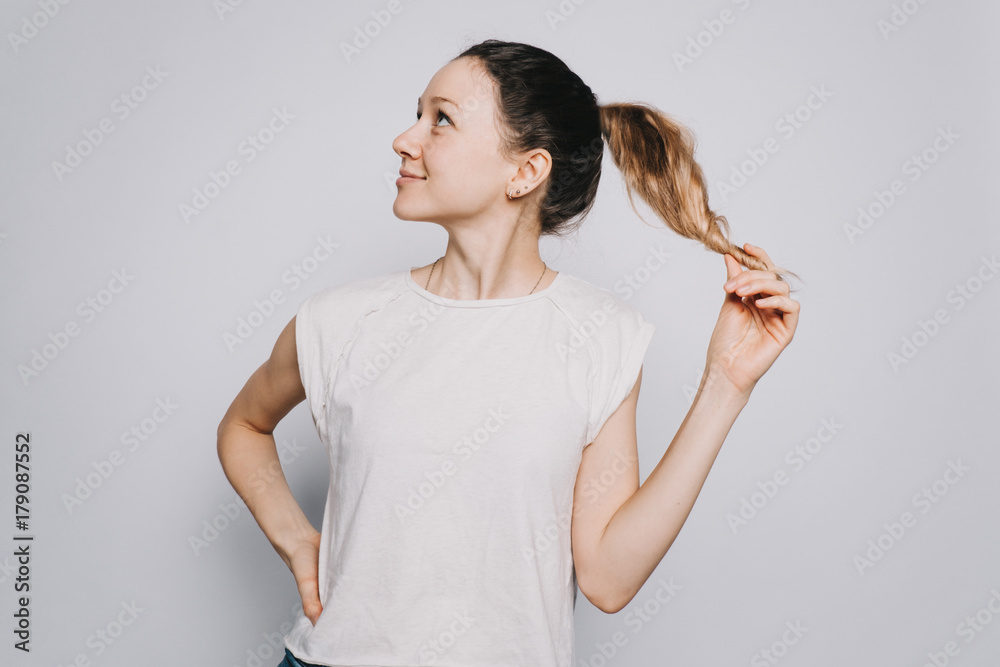 young happy girl in white t-shirt with a ponytail in profile looking in expectation of a joyful moment