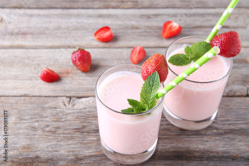 Strawberry yogurt in glass on grey wooden table