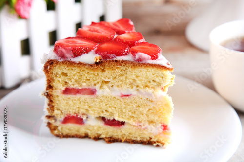 Biscuit cake with strawberries on white plate