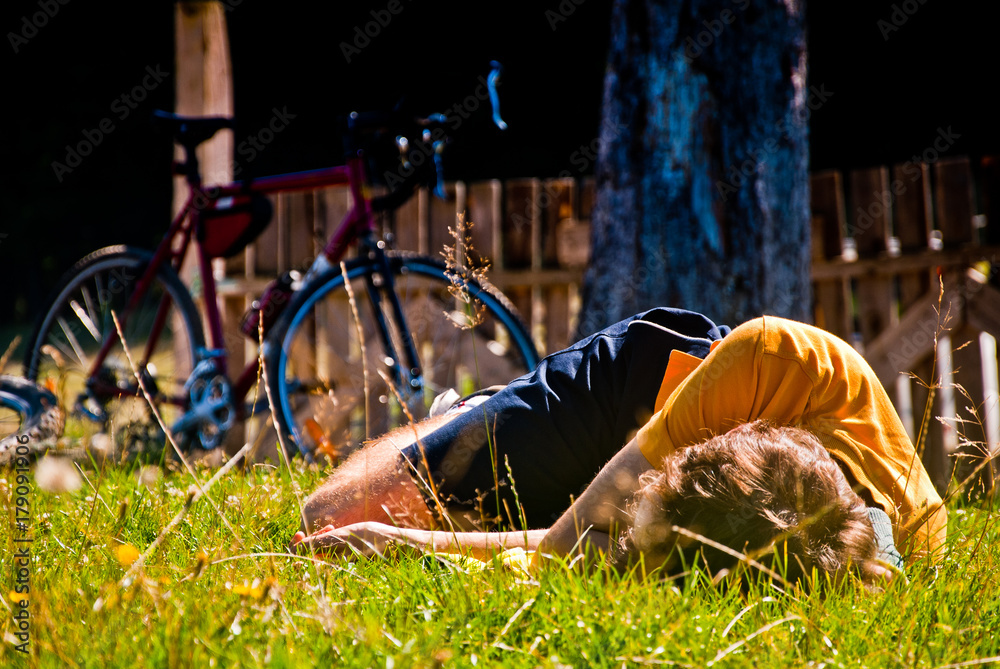 Obraz premium Rider resting on the grass near his street bicycle 