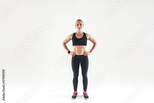 Beautiful woman in sports wear, looking at camera and smiling