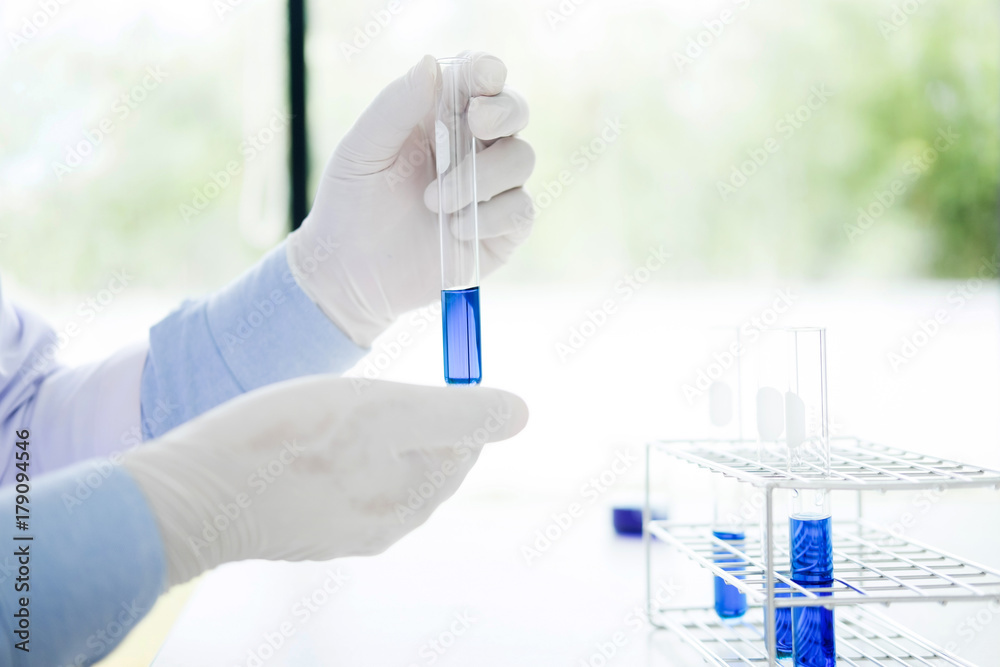 Fototapeta premium Asian scientific researcher working in laboratory holds test tube in hand a liquid solution analysis using chemical manufacturing.