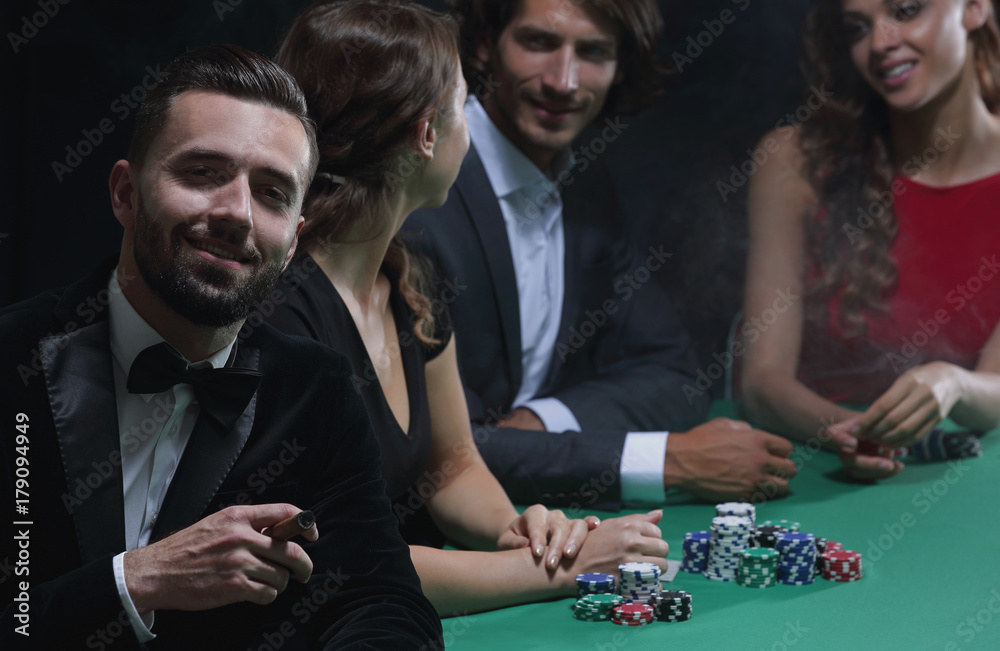 Man with cigar looking up from poker game in casino Man with cigar looking up from poker game in casino