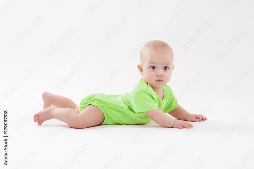 Cute curious baby lies on her stomach and looking at the camera Cute curious baby lies on her stomach and looking at the camera