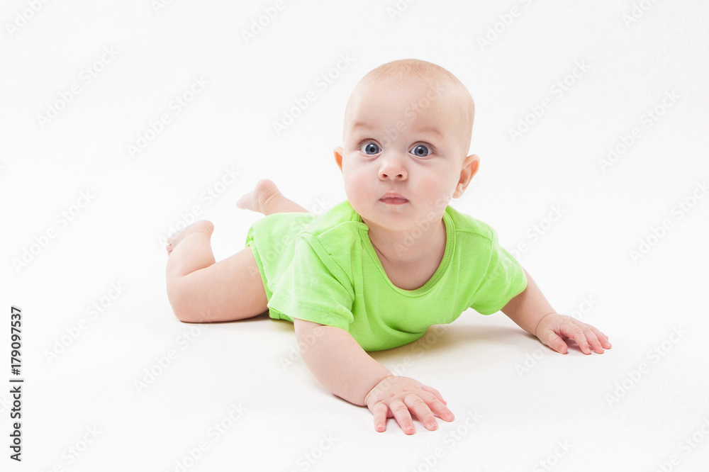 Cute curious baby lies on her stomach and looking at the camera Cute curious baby lies on her stomach and looking at the camera