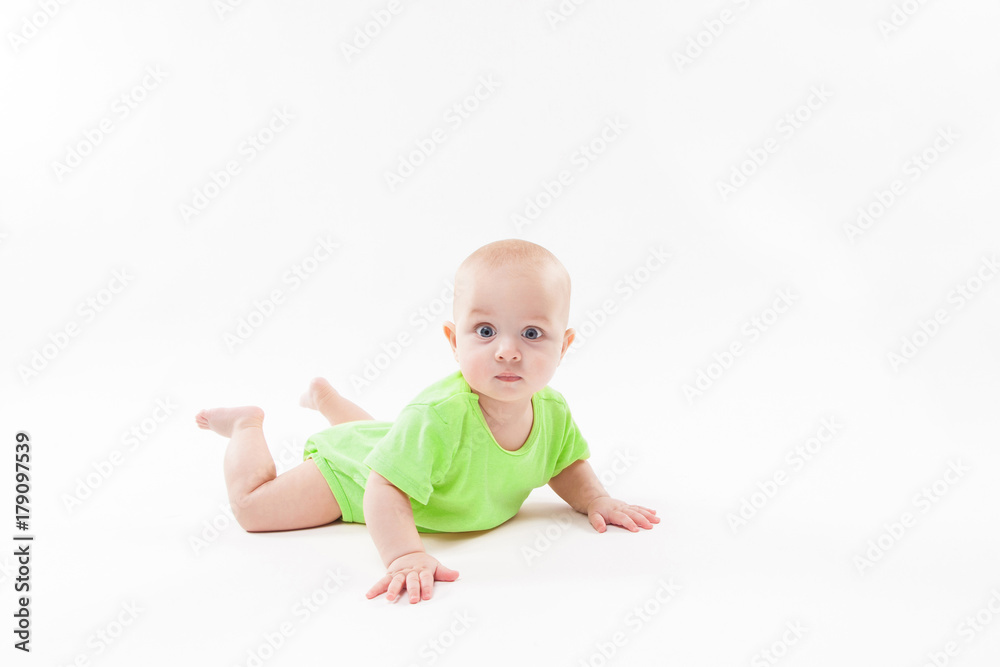Cute curious baby lies on her stomach and looking at the camera Cute curious baby lies on her stomach and looking at the camera
