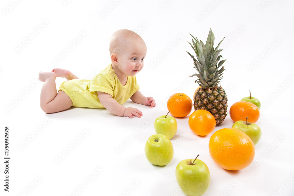 cute smiling healthy child lies on a white background among fruit cute smiling healthy child lies on a white background among fruit
