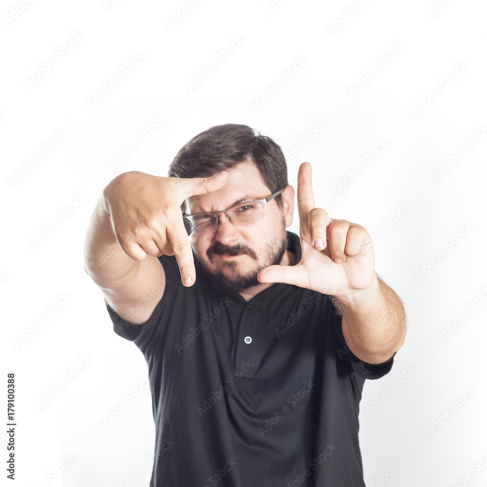 Portrait of 30 years old man with glasses and beard. Photographer or operator checking composition in frame of his finger Portrait of 30 years old man with glasses and beard. Photographer or operator checking composition in frame of his finger