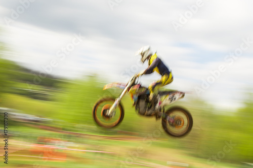 Motocross bike rider jumping in motion