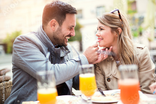Couple eating pizza snack outdoors.